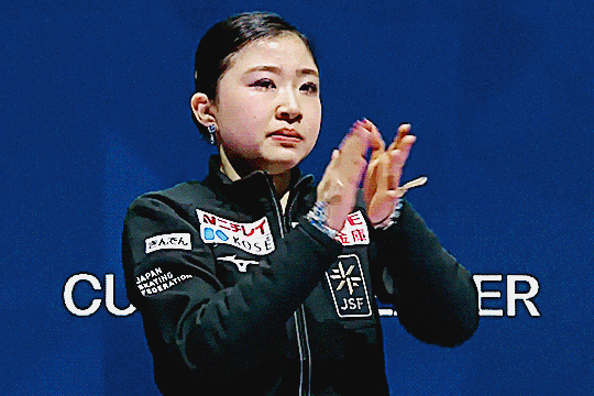 mone chiba in tears standing and clapping from the leader's chair after kaori sakamoto's last skate at worlds