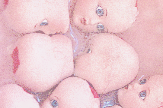 original photo by mike krzeszak featuring an unsettling pile of semi-realistic, bald white doll heads with inset eyes. the image is hazy and tinted pink with noise added on top.