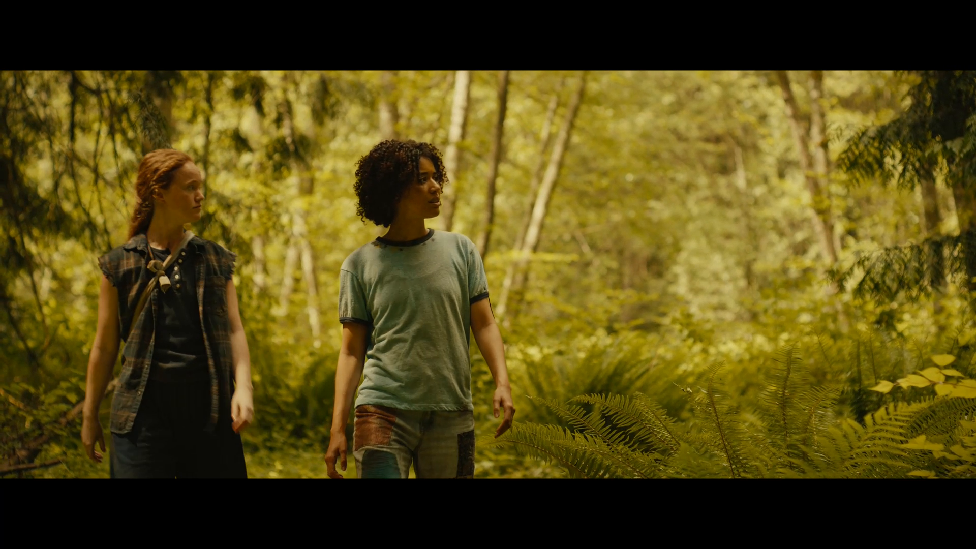 teen taissa and van walking through a sunny forest in yellowjackets season 3
