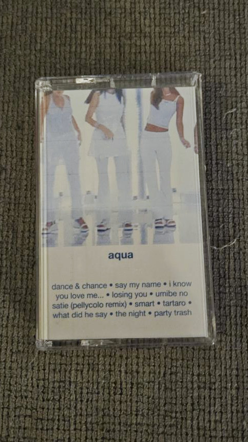 my physical recorded tape for the below playlist in a case with a custom j-card showing the cover art, which is a screen shot from the coconuts musume dance & chance music video showing a cropped shot of some of the members dancing, and a list of the tracks
