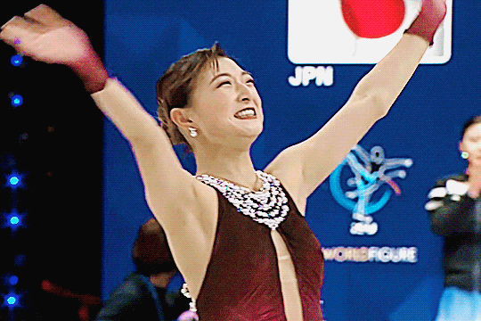 kaori sakamoto waving at the audience and skating around as she smiles brightly after her final skate at worlds 2026 before her retirement