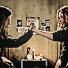 ginger and brigitte in ginger snaps sitting across from each other with one arm each outstretched and hands intertwined