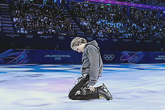 ilia malinin at the olympics figure skating gala, having fallen to his knees on the ice, moving around as if having given up