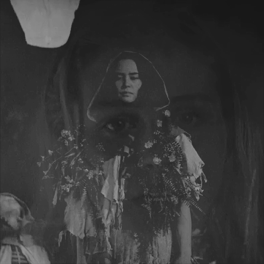 two black and white GIFs layered on top of each other. the first one is lottie with the rest of the yellowjackets behind her as they lift lanterns - lottie watches one. the second one is laura lee in the plane as it burns and smokes before it explodes