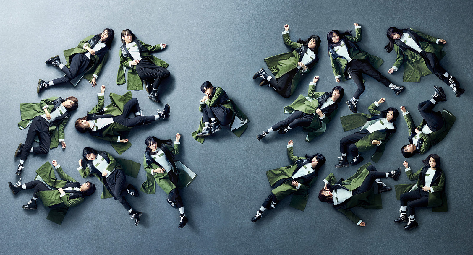 keyakizaka46 black sheep promotional banner featuring the members laying on a floor, the camera taking a shot from above, isolated by themselves wearing long green jackets with pensive looks. the center of the song, hirate yurina, is in the middle, curled into herself