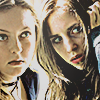 light toned composite icon of ginger and brigitte where ginger looks up at a shy, eerie looking brigitte who has a hand in her hair