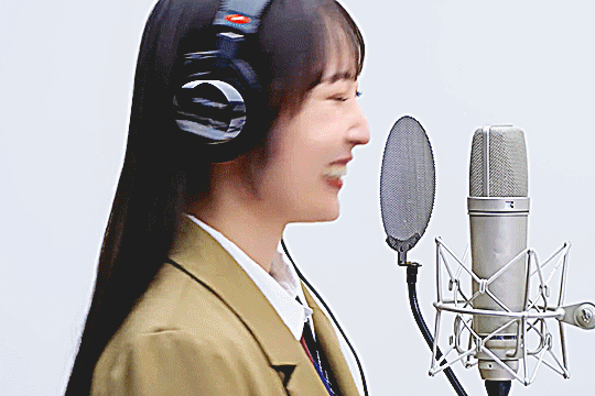 dambara ruru talking into the mic and smiling while on the set of the FIRST TAKE